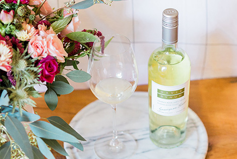 Bottle and glass of Davis Bynum Sauvignon Blanc on a table with flowers